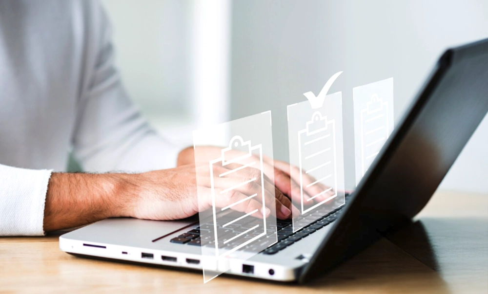 Immagine tematica con uomo che lavora su un computer portatile, controllando e leggendo documenti