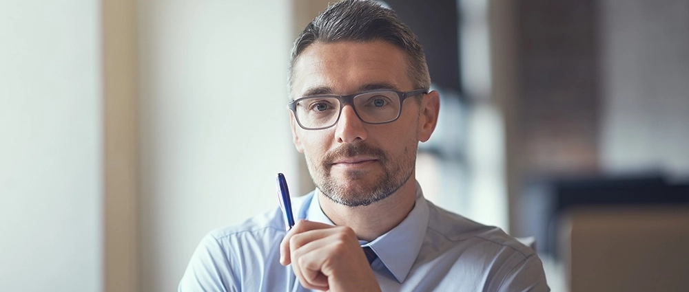 Immagine tematica di giovane uomo con occhiali che controlla accoglie i clienti.