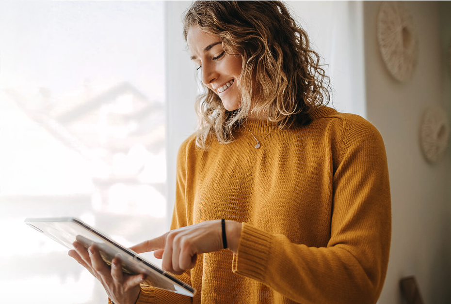 Immagine tematica di giovane donna sorridente che controlla i costi delle utenze su un moderno tablet.