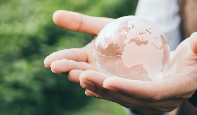 Due mani che reggono un globo trasparente con la mappa della Terra